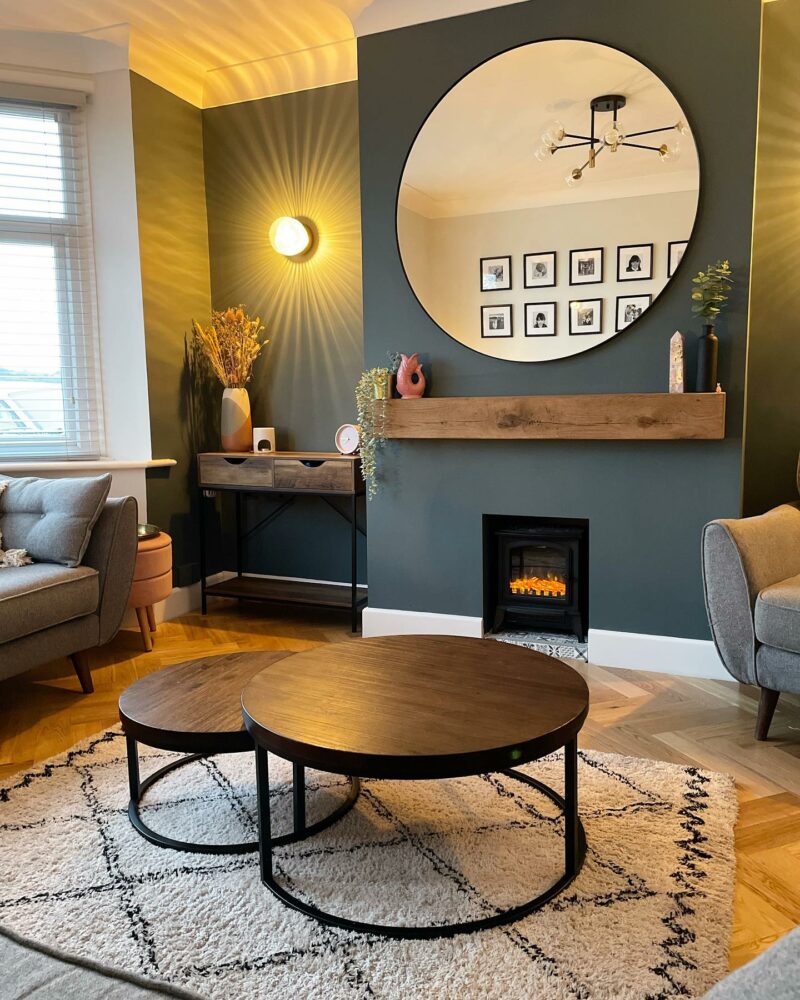 Oak Furnitureland industrial-style Detroit glazed nest of coffee tables in a living room with an inky blue wall.